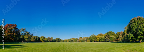 Panorama of empty Great Lawn of Central Park under clear blue sky, in Manhattan, New York City, USA