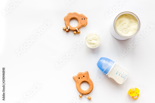 Craft toys for kids. Developing rattle for the smallest and baby bottle with milk. White background top view mock up