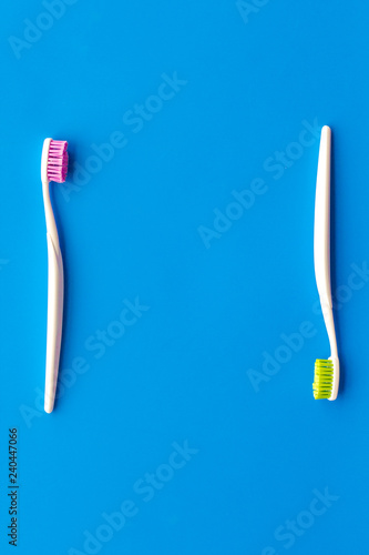 Daily oral hygiene for family. Toothbrush on blue background top view mock up