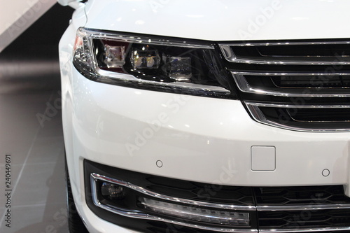 White front bumper with headlight of a car, Parking sensors and daytime running light close up © Ilya