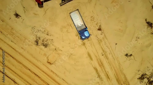 fantastic upper motion close above yellow sand quarry to truck and excavator among deep truck tracks