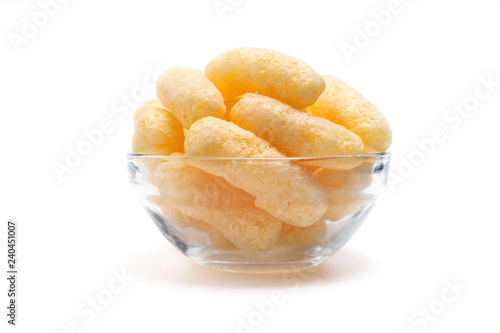 Yellow Corn Puffs in a Glass Bowl Isolated On White Background. Crunchy Flavored Puffed Snacks. Party, Movie, TV, Game Snacks.