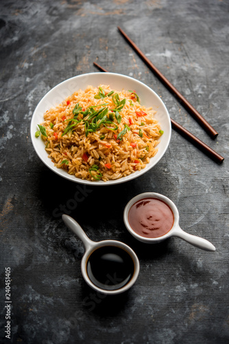 Canvas Print Schezwan Fried Rice Masala is a popular indo-chinese food served in a plate or bowl with chopsticks