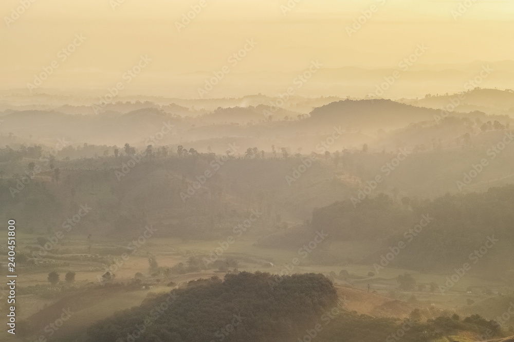 Obraz premium sunrise at Doi Mae Salong, beautiful mountains with many hills around with soft mist and yellow sun light in the sky background, Doi Mae Salong View Point, Chiang Rai, northern Thailand.