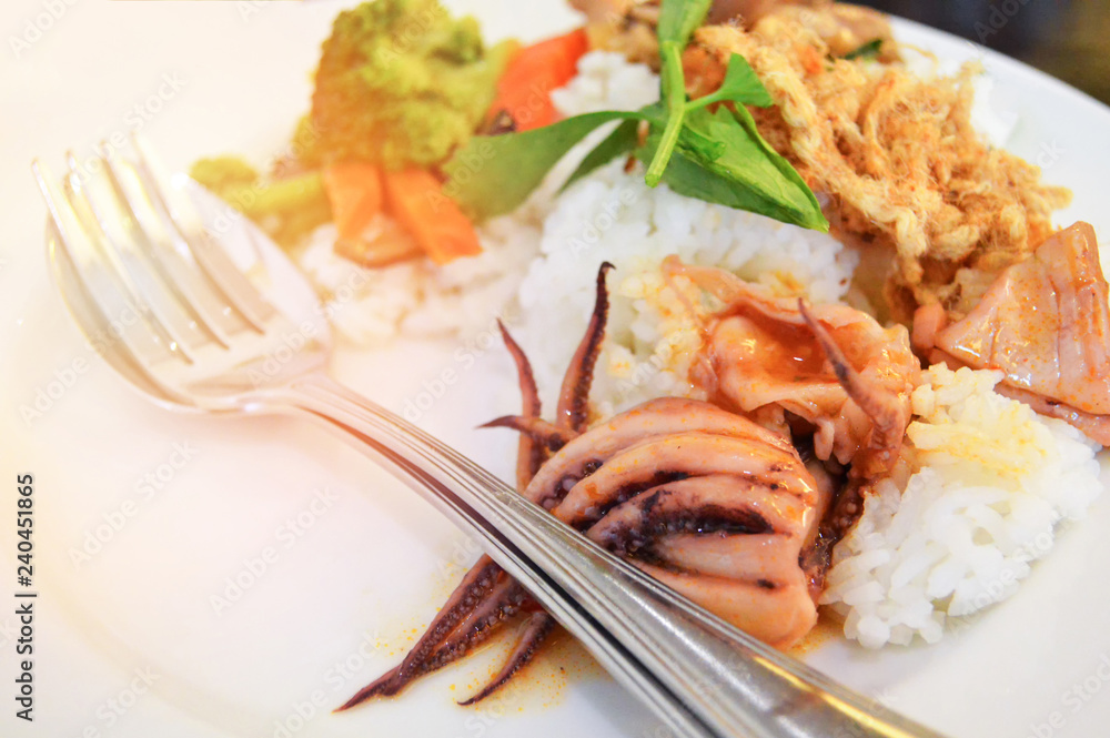 Breakfast stir fried squid with mixed vegetable carrot mushroom and broccoli on rice white plate Breakfast stir fried squid with mixed vegetable carrot mushroom and broccoli on rice white plate