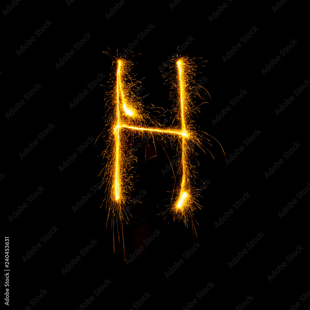 Alphabet sparklers on black background single letter