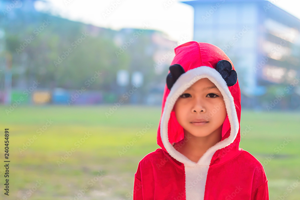 Asia boy wearing a red Christmas Background on the school lawn. Asia boy wearing a red Christmas Background on the school lawn.