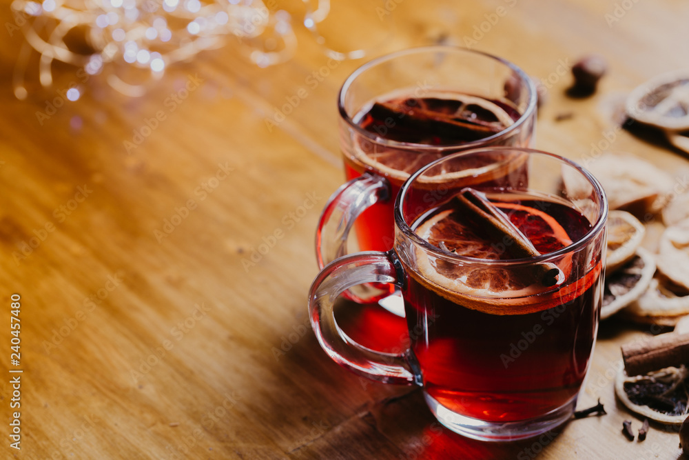Mulled wine in mugs with scarf on wooden table. Mulled wine in mugs with scarf on wooden table.