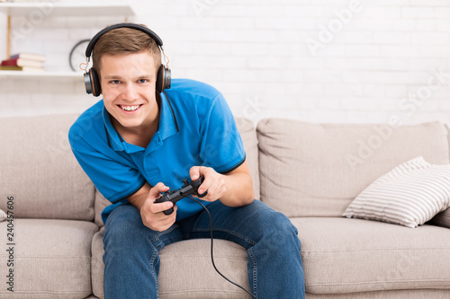 Young guy enjoying web game, playing with joystick