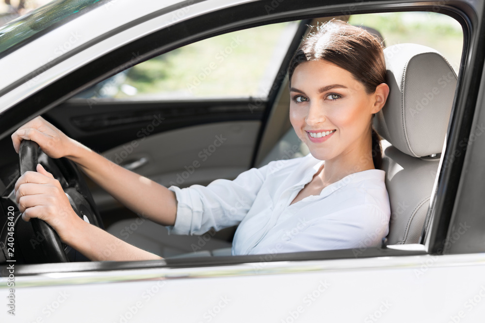 Business woman driving car, sitting in automobile