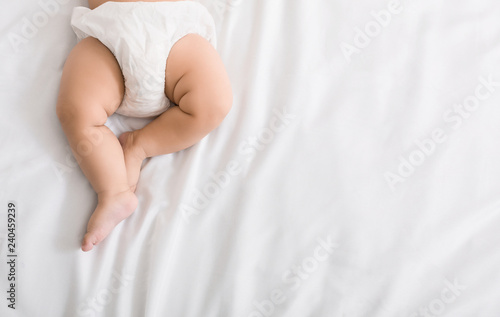 Quadro em tela Baby legs and bottom in diaper on bed