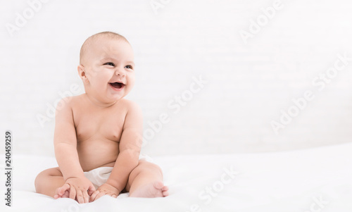 Cute baby sitting on white background, copy space photo