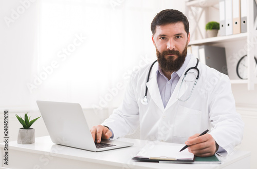 Doctor working with laptop computer in office