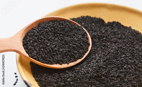 Black cumin seeds in wooden bowl and spoon