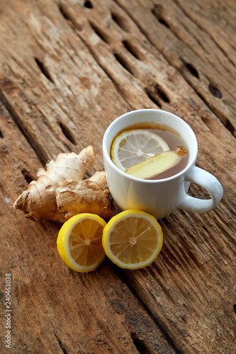 Cup of ginger tea with lemon on wooden