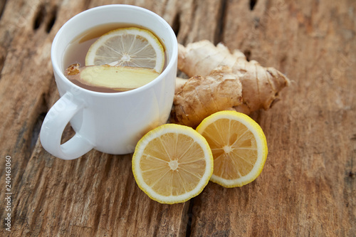 Cup of ginger tea with lemon on wooden