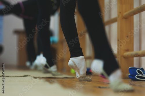 Close up of feet of young gymnast stretching tip toes at the gym club. Close up of feet of toe-pointing of young ballerinas at the dance studio