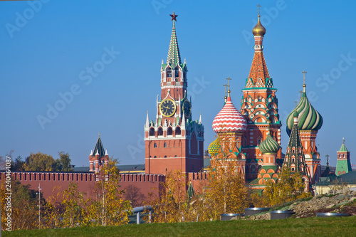 Moscow Kremlin on a background of green lawn and autumn birch trees.