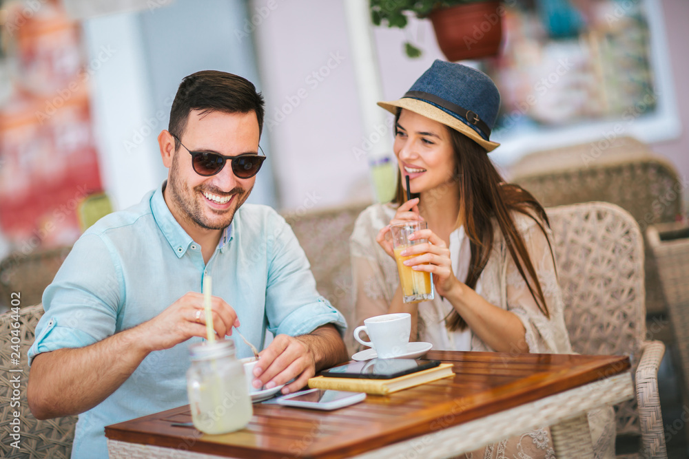 Beautiful loving couple sitting in a cafe enjoying in coffee and conversation, selective focus Beautiful loving couple sitting in a cafe enjoying in coffee and conversation, selective focus