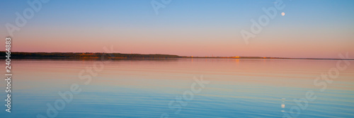 Panorama of the turquoise dawn of the sky and water of pink and turquoise color  the sun rises