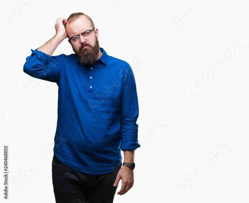 Young caucasian hipster man wearing glasses over isolated background confuse and wonder about question. Uncertain with doubt, thinking with hand on head. Pensive concept.