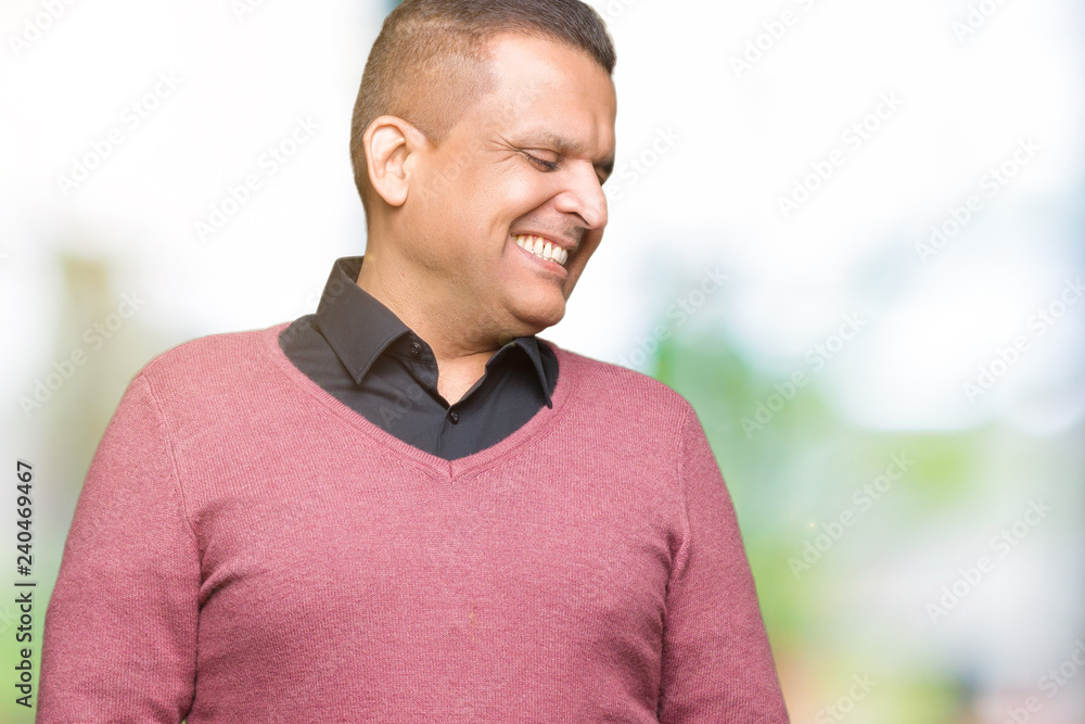 Middle age arab man over isolated background looking away to side with smile on face, natural expression. Laughing confident. Middle age arab man over isolated background looking away to side with smile on face, natural expression. Laughing confident.