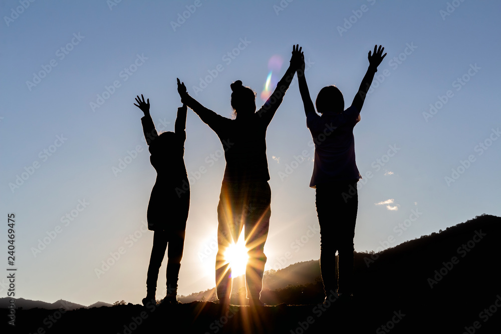 silhouette of people group with raised hands on the mountain at the sunset or sunrise time. silhouette of people group with raised hands on the mountain at the sunset or sunrise time.