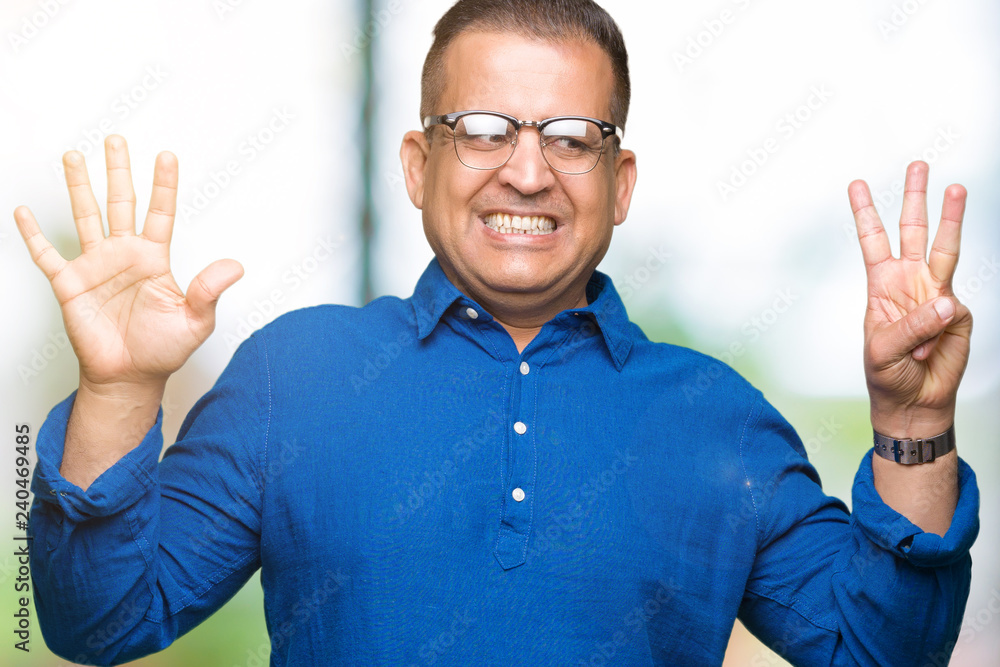 Naklejka premium Middle age arab man wearing glasses over isolated background showing and pointing up with fingers number eight while smiling confident and happy.