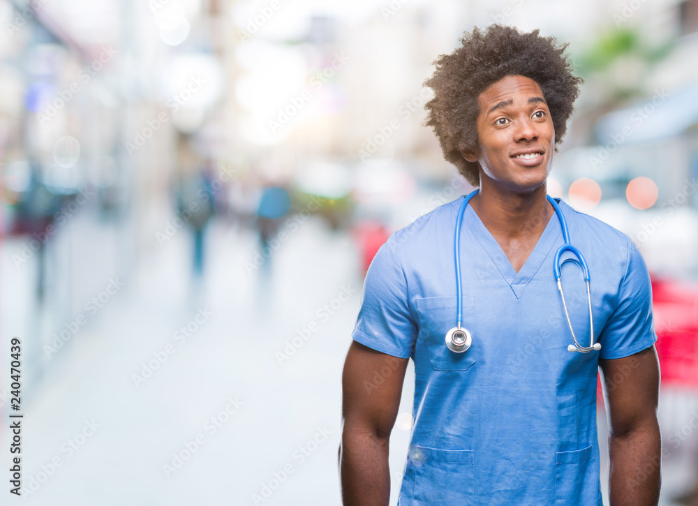Afro american surgeon doctor man over isolated background smiling looking side and staring away thinking. Afro american surgeon doctor man over isolated background smiling looking side and staring away thinking.