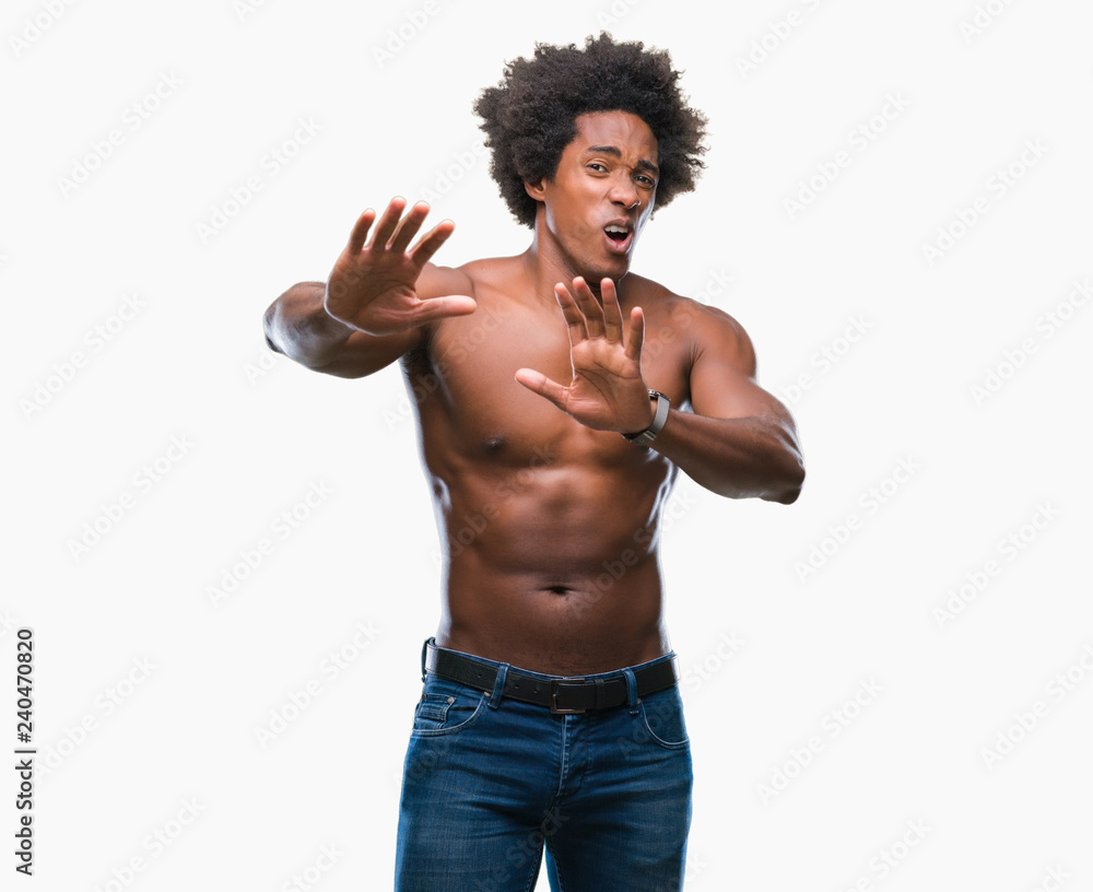 Fototapeta premium Afro american shirtless man showing nude body over isolated background afraid and terrified with fear expression stop gesture with hands, shouting in shock. Panic concept.