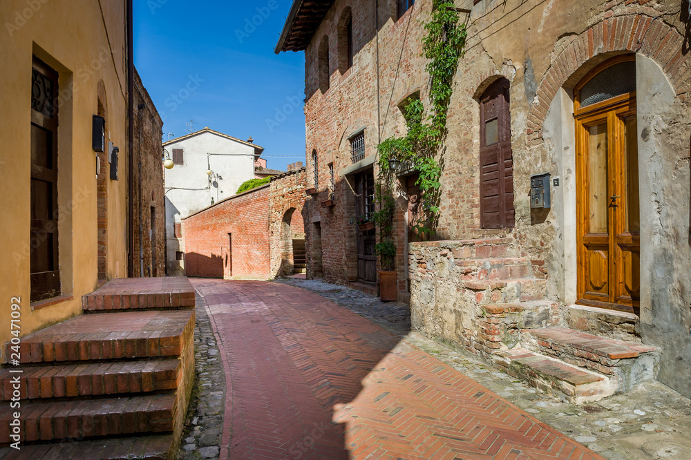 Narrow empty street with medieval houses of Certaldo
