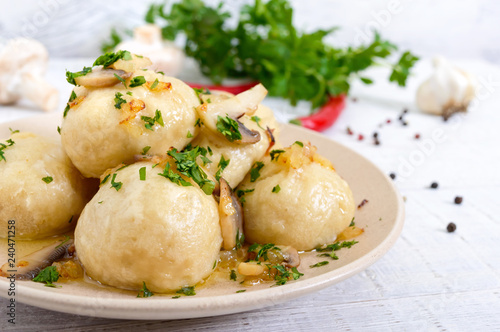 Ukrainian dumplings with meat and mushrooms in a bowl on a white background.