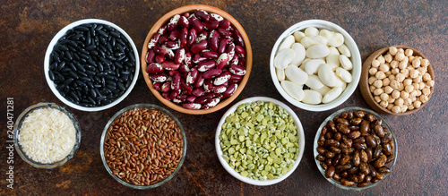 Healthy food, dieting, nutrition concept, vegan protein source. Assortment of colorful raw legumes: green peas, beans, chickpeas, rice in bowls. Banner.
