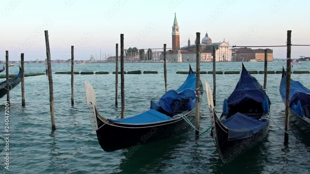 Slow Motion of beautiful view of traditional Gondolas moored on San Marco square with historic church of San Giorgio Maggiore in the background. Venetian canals. Venice, Italy-Dan Slow Motion of beautiful view of traditional Gondolas moored on San Marco square with historic church of San Giorgio Maggiore in the background. Venetian canals. Venice, Italy-Dan