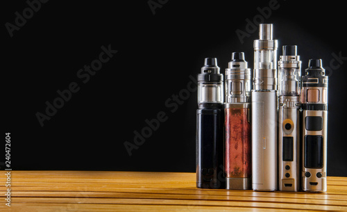 Popular vaping e cig devices mod.electronic cigarette over a black background. vaporizer e-cig old device model. pen cigarette