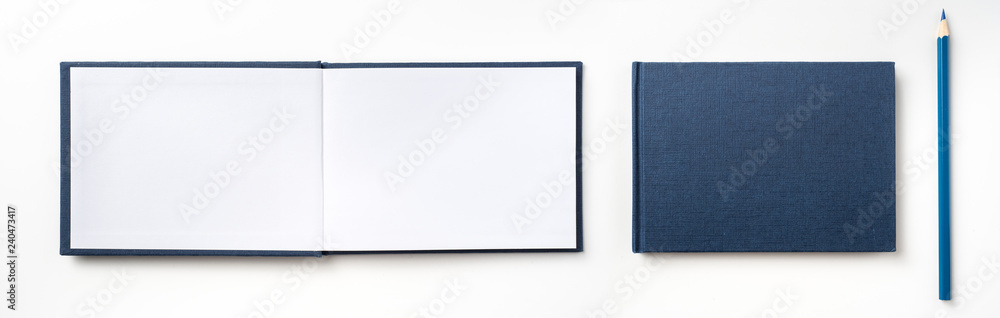 Top view of blue hardcover notebook and pencil