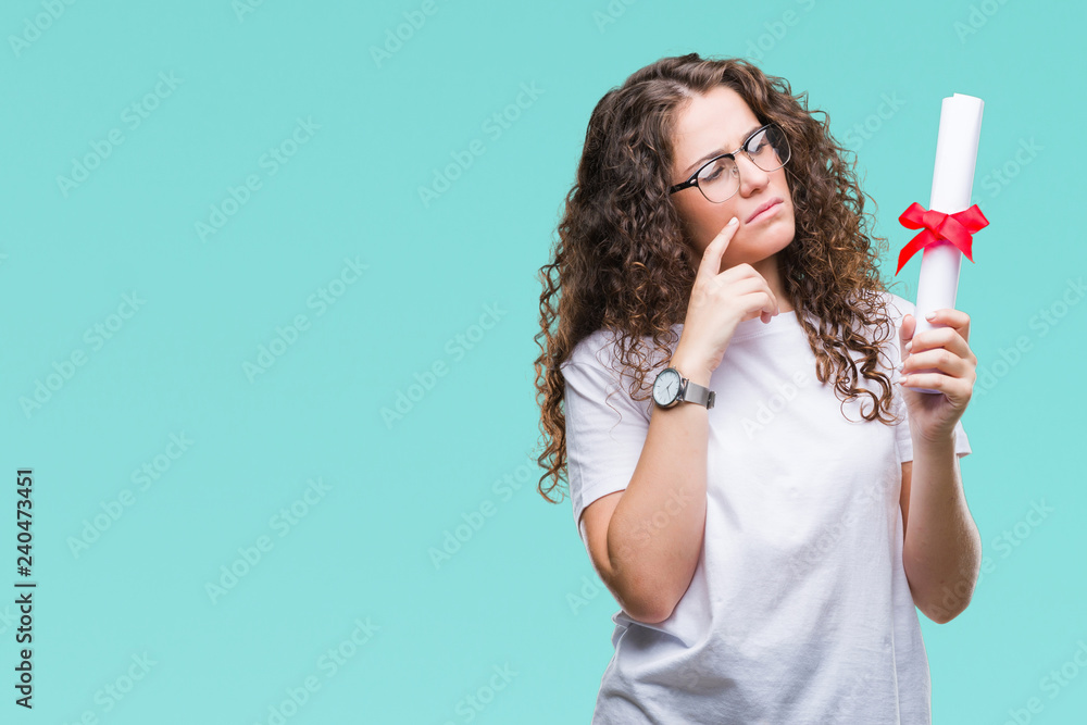 Young brunette girl holding degree and wearing glasses over isolated background serious face thinking about question, very confused idea Young brunette girl holding degree and wearing glasses over isolated background serious face thinking about question, very confused idea