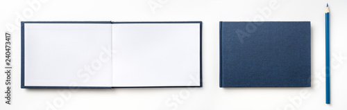 Top view of blue hardcover notebook and pencil