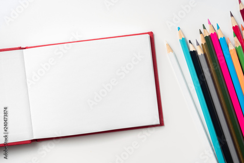 Top view of red hardcover notebook and pencil
