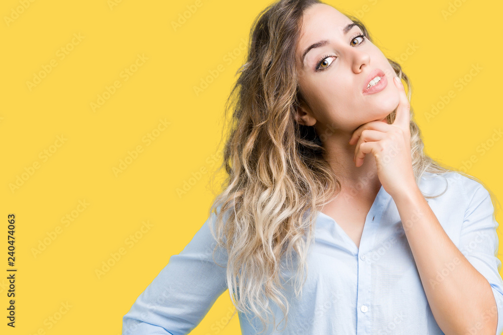 Beautiful young blonde business woman over isolated background with hand on chin thinking about question, pensive expression. Smiling with thoughtful face. Doubt concept. Beautiful young blonde business woman over isolated background with hand on chin thinking about question, pensive expression. Smiling with thoughtful face. Doubt concept.