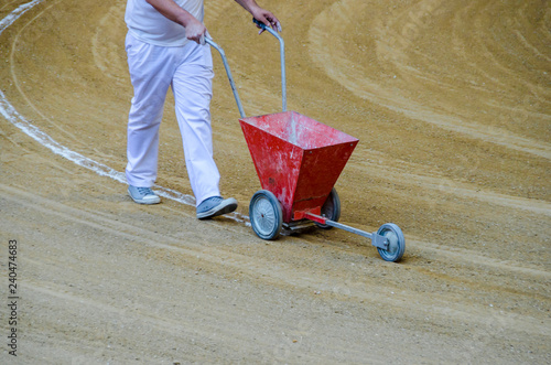 Arenero painting bullring lines in the sand