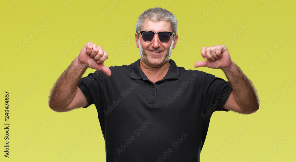 Naklejka premium Handsome senior man wearing sunglasses over isolated background looking confident with smile on face, pointing oneself with fingers proud and happy.