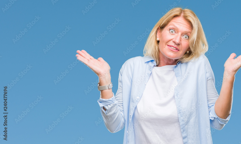 Fototapeta premium Middle age blonde woman over isolated background clueless and confused expression with arms and hands raised. Doubt concept.
