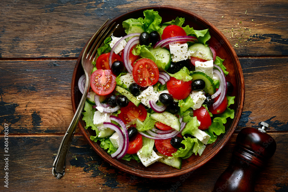 Traditional greek salad with vegetables and feta cheese.Top view with copy space.