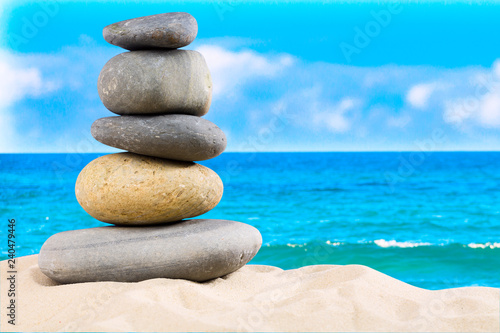 Zen rock, concept of harmony and balance. Zen stones pyramid on the beach with amazing turquoise blue water sea and sky