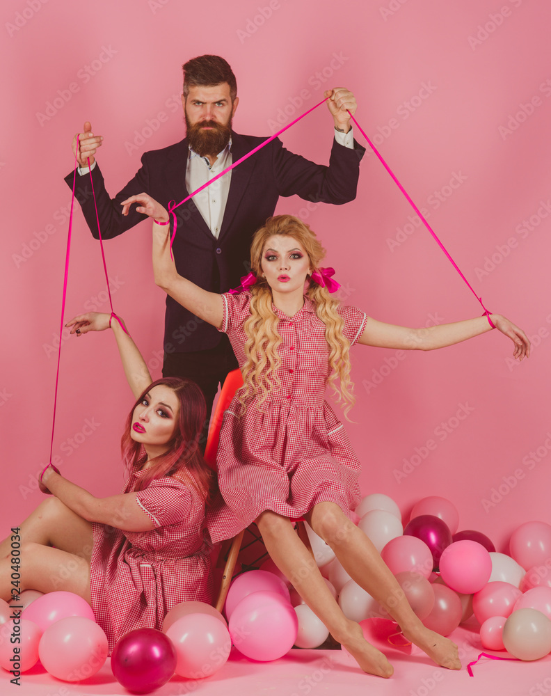 retro girls and master in party balloons. Creative idea. Love triangle.  Crazy girls and man on pink. Halloween. vintage fashion women puppet and  man. holidays and dolls. dominance and dependence Stock Photo