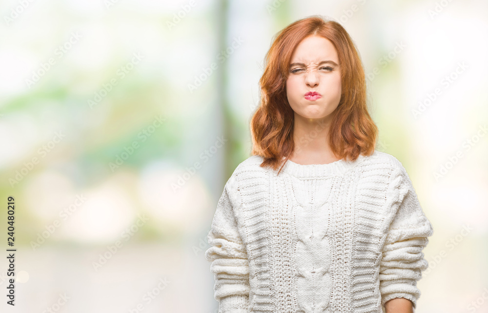 Young beautiful woman over isolated background wearing winter sweater puffing cheeks with funny face. Mouth inflated with air, crazy expression. Young beautiful woman over isolated background wearing winter sweater puffing cheeks with funny face. Mouth inflated with air, crazy expression.