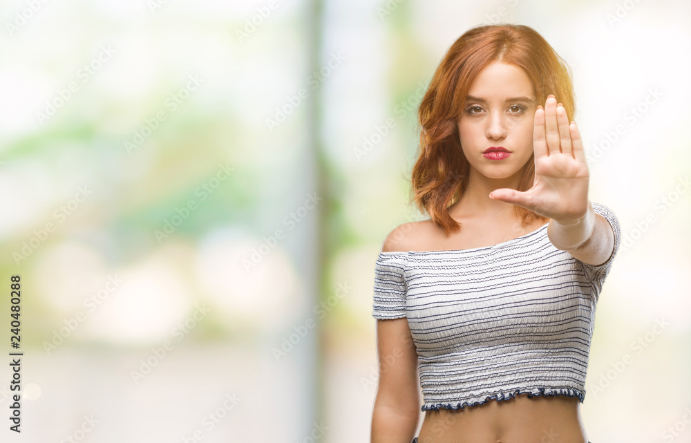 Young beautiful woman over isolated background doing stop sing with palm of the hand. Warning expression with negative and serious gesture on the face.