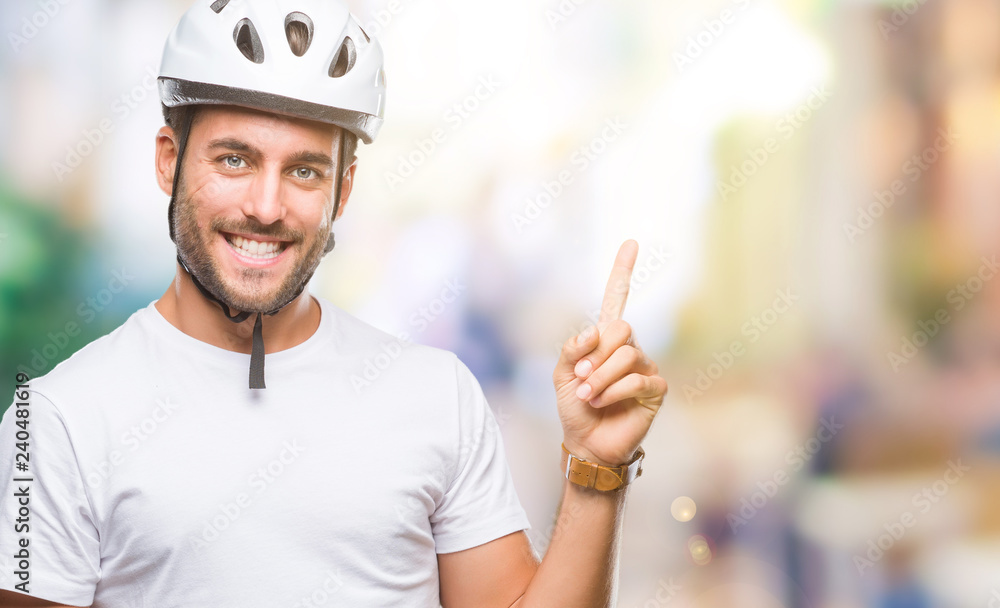 Young handsome man wearing cyclist safety helmet over isolated background with a big smile on face, pointing with hand and finger to the side looking at the camera. Young handsome man wearing cyclist safety helmet over isolated background with a big smile on face, pointing with hand and finger to the side looking at the camera.