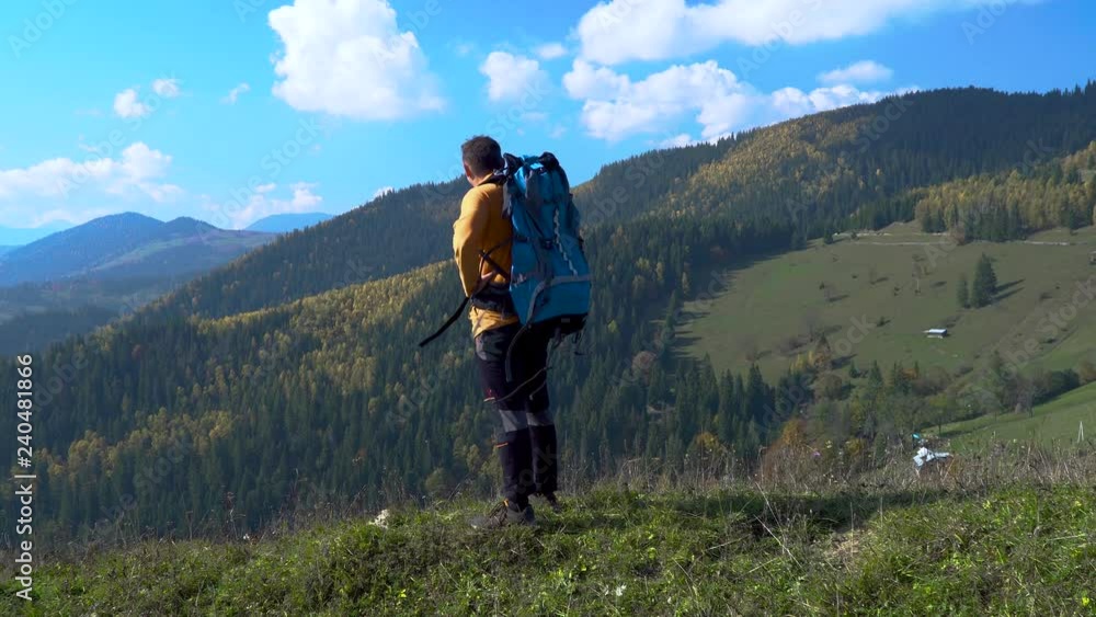 A man with a backpack travels in the Carpathian Mountains. He enjoys nature in his hike. 4K A man with a backpack travels in the Carpathian Mountains. He enjoys nature in his hike. 4K